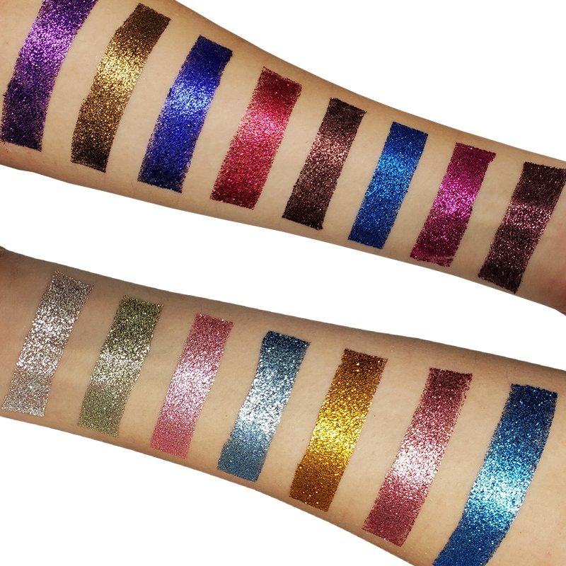 Close-up arm swatches of glitter eyeshadows in gold, blue, pink, purple, and green tones