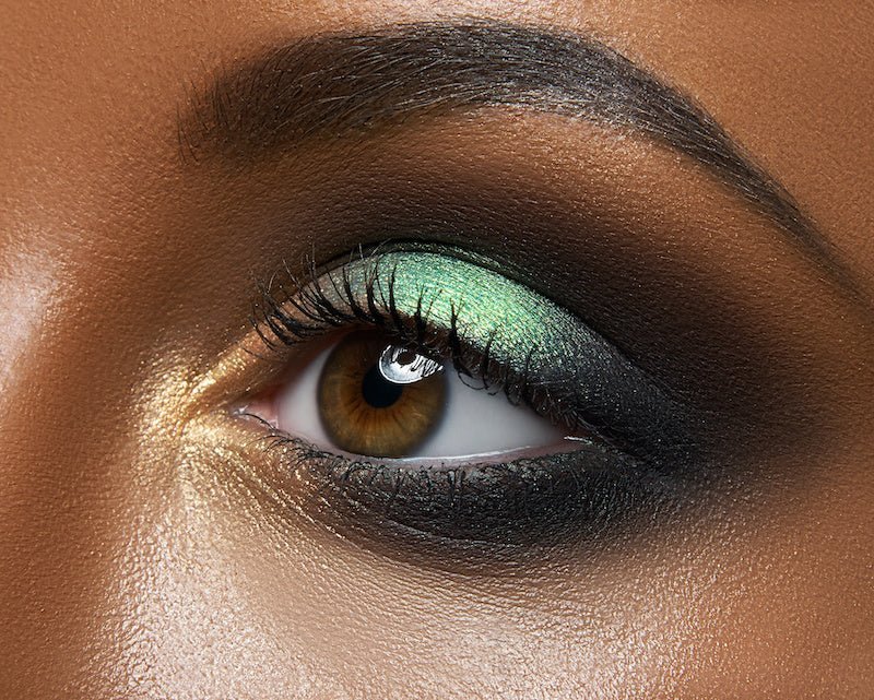 Glitter eyeshadow look with teal shimmer on the lid and smoky black blended shadow