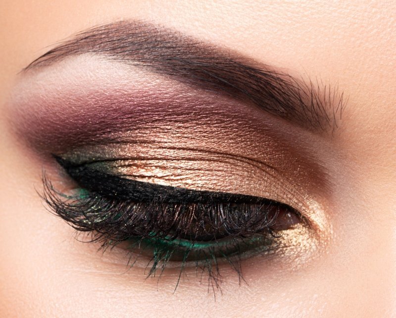 Glitter eyeshadow palette eye look with bronze, plum, and green shimmer tones
