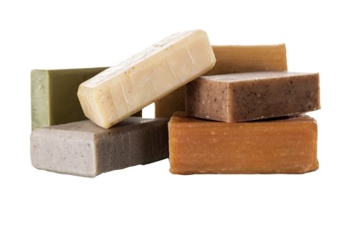 Stack of turmeric cleanser soap bars in golden, brown, and light gray blocks