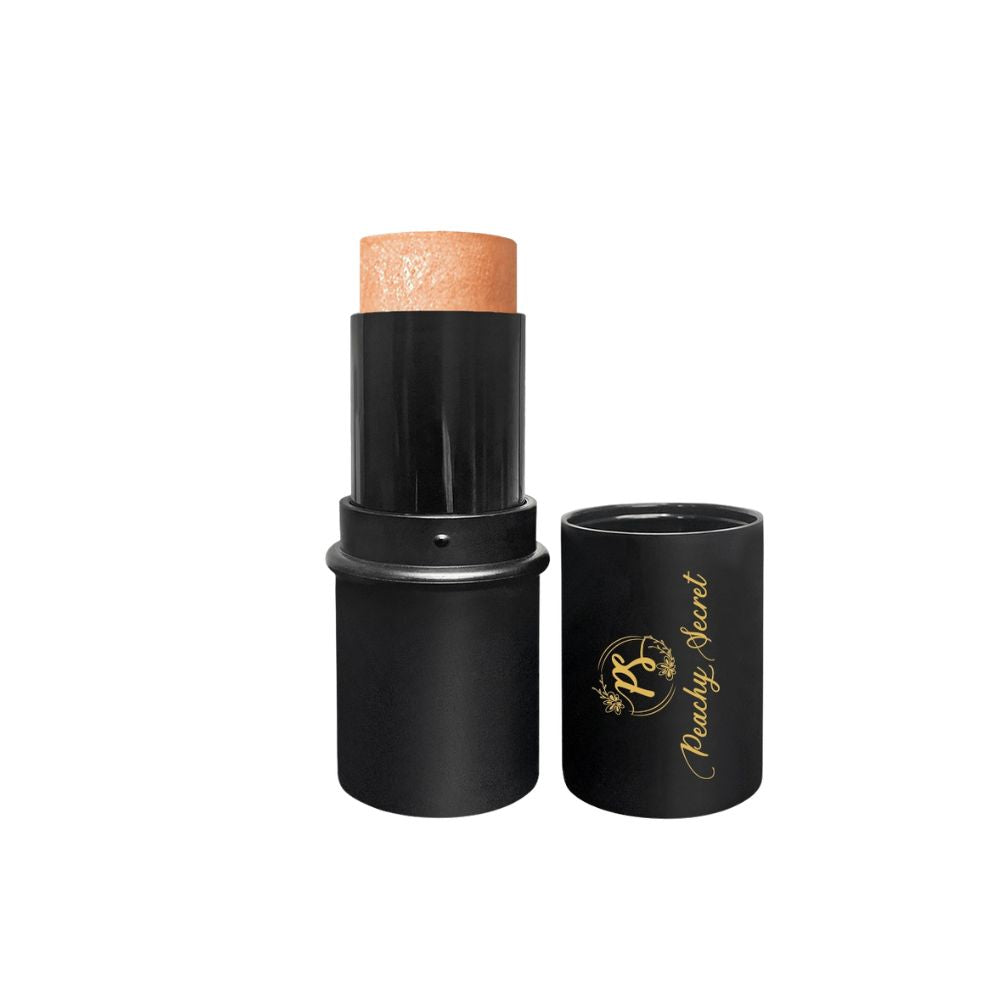 Botanical highlighter stick with copper-toned tip in black tube and cap
