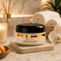 Apricot body scrub jar with black lid on speckled stone base