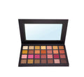 Open eyeshadow palette with assorted warm and neutral shades in a black case